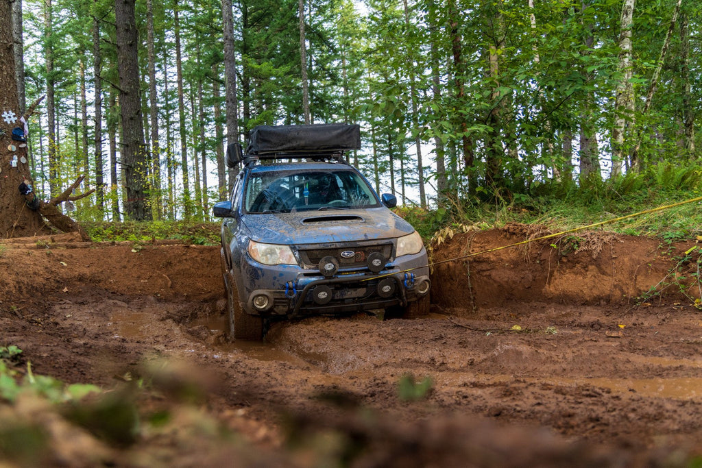 Subaru Forester driving through mud puddle offroad