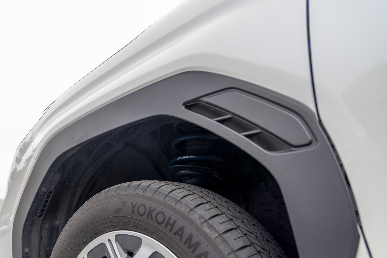Close-up of a car's wheel well showing RalliTEK spring installed