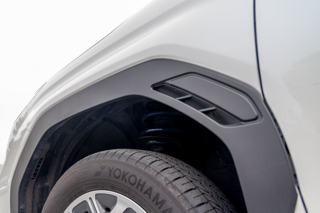 Close-up of a car's wheel well showing RalliTEK spring installed