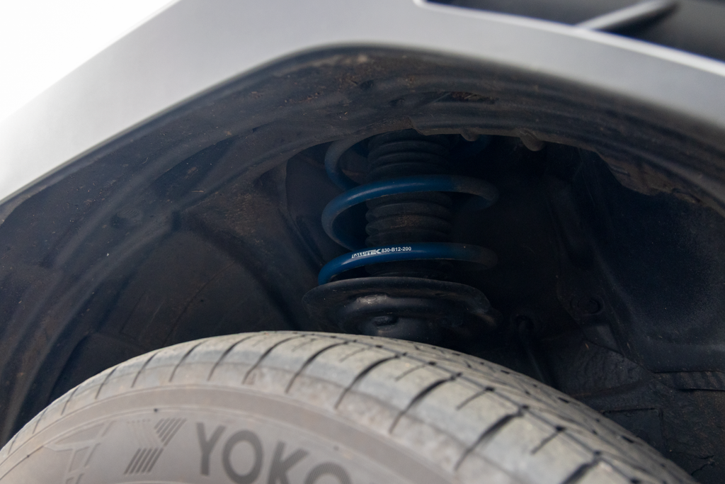 Close-up of a spring installed with RalliTEK branding, focusing on the spring installed on the strut assembly