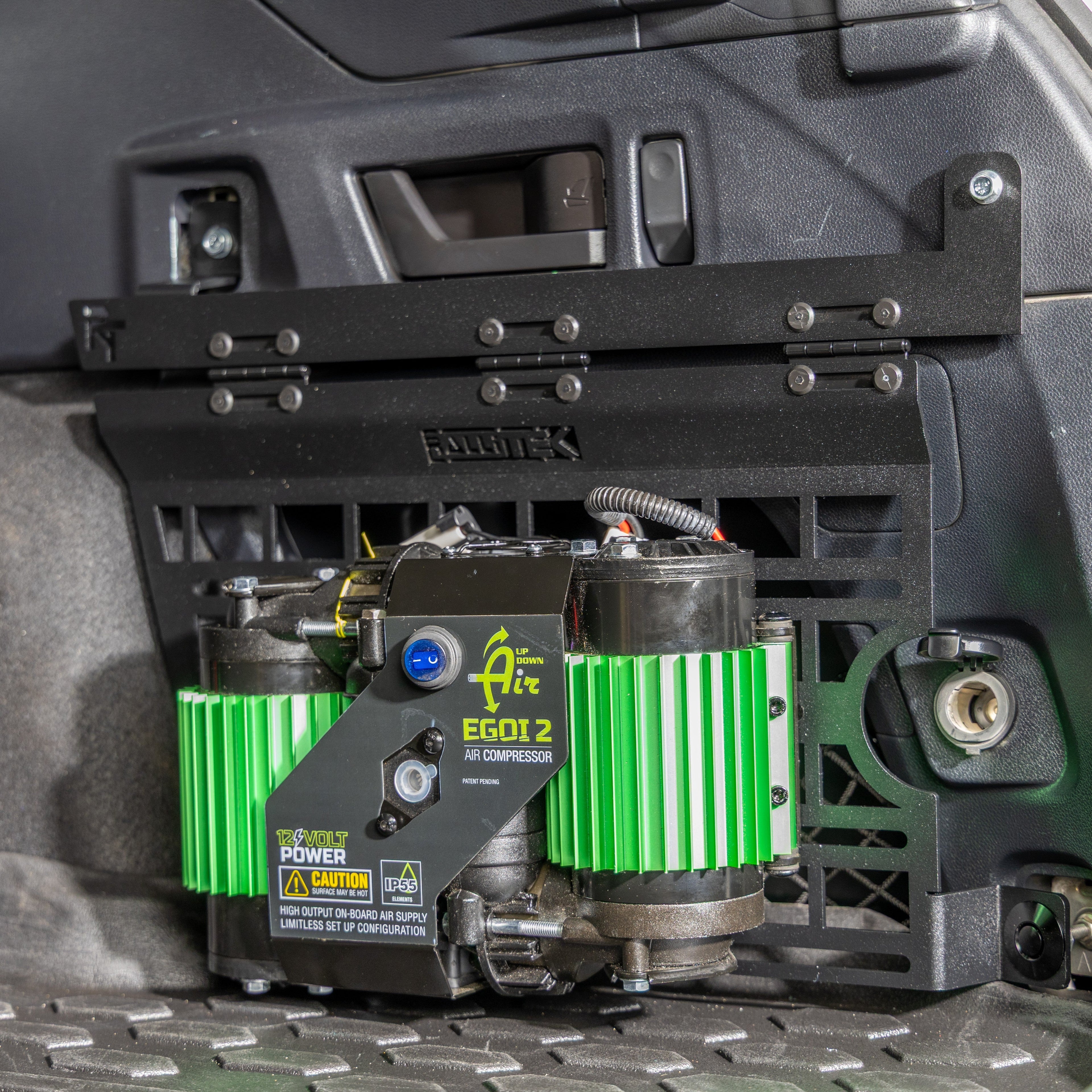 subaru outback molle panel installed in rear cargo storage area with air compressor mounted on it